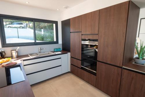 - une cuisine avec des placards en bois et un four ouvert dans l'établissement Maredo - West Corsica Stunning view, Infinity pool, à Tiuccia