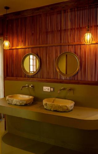two sinks in a bathroom with two mirrors at Mateves boutique lodge in Arusha