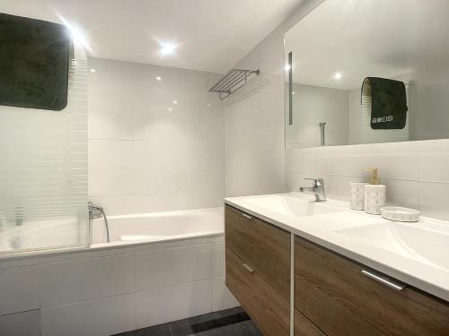 une salle de bain blanche avec un lavabo et une baignoire dans l'établissement Loft moderne dans le centre de Cannes, à Cannes