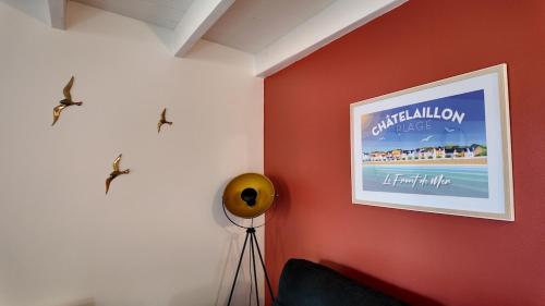 un muro rosso con l'immagine di una spiaggia di La Madeleine, 4 vélos, 200m de la plage, Clim, Terrasse, Barbecue a Châtelaillon-Plage