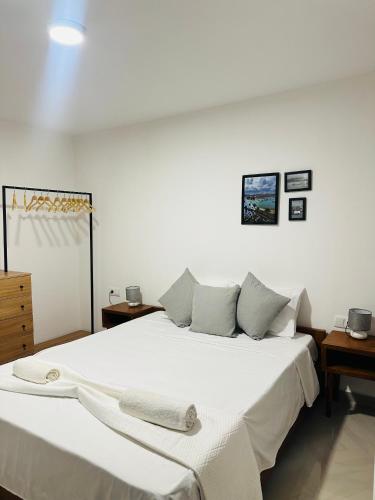 a bedroom with a large bed with white sheets and pillows at T2 Centro cidade in Mindelo
