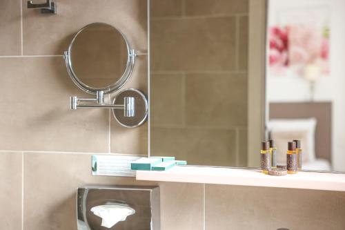 a bathroom with a mirror and a sink at Hôtel CASABELLA Cannes Mouans Sartoux in Mouans-Sartoux