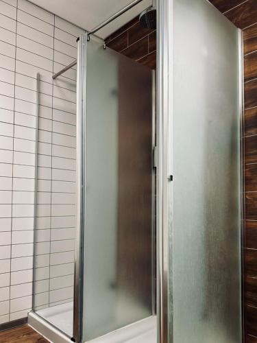 a shower with a glass door in a bathroom at Aliança café & hostel in Angra do Heroísmo