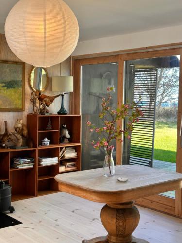 a room with a table with a vase on it at Seaside holiday home in Grenå