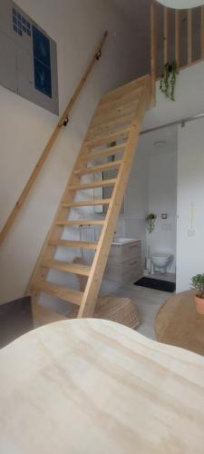 a wooden staircase in a living room with a stair case at Vergroening in IJzendijke
