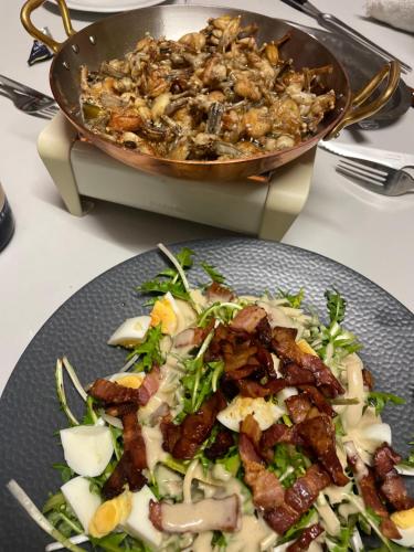 a plate of food next to a pot of food at Logis Hôtel & Restaurant Les Perce-Neige in Bonnétage