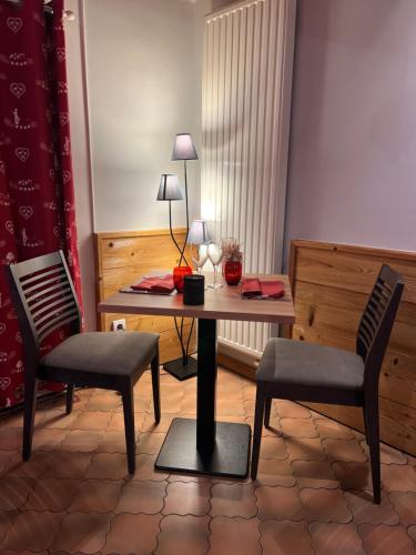a room with a table and two chairs at Logis Hôtel & Restaurant Les Perce-Neige in Bonnétage