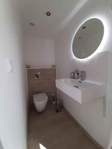 une salle de bain blanche avec un lavabo et un miroir dans l'établissement Cassiopée - CIEL ETOILE, à Honfleur