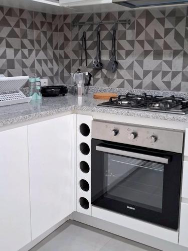 a kitchen with a black and white stove top oven at R3 Apartments - Laginha in Mindelo
