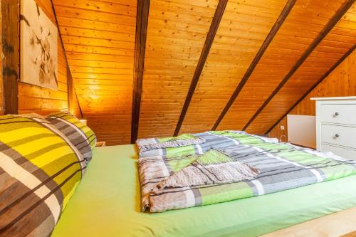 a bed in a room with a wooden ceiling at Ferienwohnungen Zum Hasenbahnhof in Kirchhundem