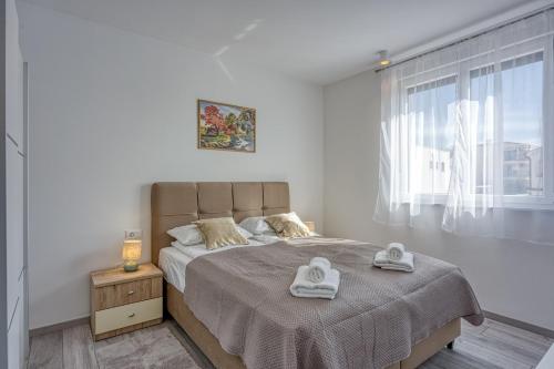 Un dormitorio con una cama con dos toallas encima. en Monika&Jozsef, en Poreč