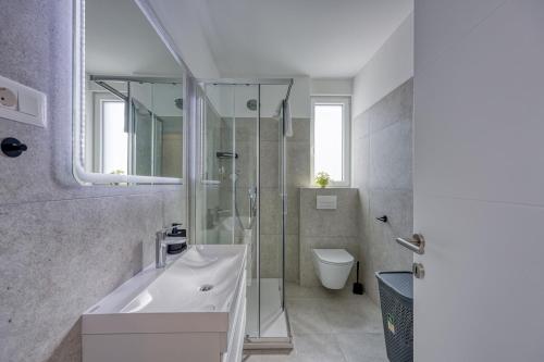 Un baño con lavabo, ducha e inodoro. en Monika&Jozsef, en Poreč