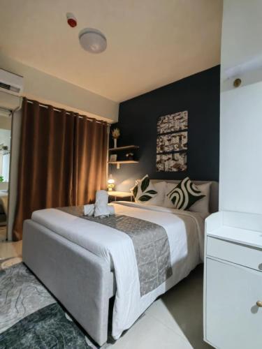 a bedroom with a large bed with black walls at Simple Haven at Inspiria Davao Beside Abreeza Mall - Fully Equipped Studio in Davao City