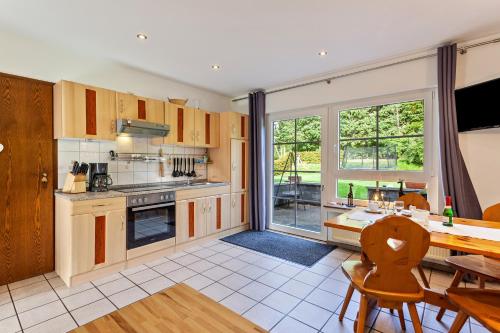 a kitchen with a table and a dining room at Ferienwohnungen Zum Hasenbahnhof in Kirchhundem