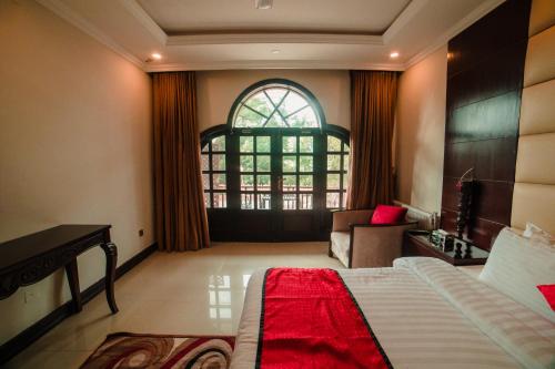 a bedroom with a bed and a desk and a window at Shangrila Hotels and Resort in Murree