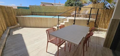 a table and chairs on a patio with a pool at Amdar Holiday Apartments in Eilat