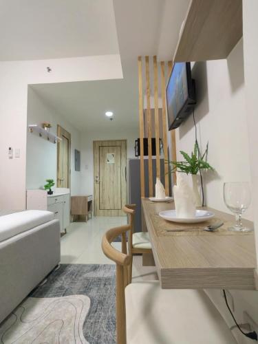 a living room with a couch and a table with a tv at Simple Haven at Inspiria Davao Beside Abreeza Mall - Fully Equipped Studio in Davao City
