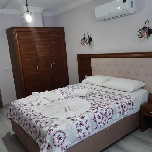 a bedroom with a bed with a floral bedspread at Yuvarlakçay pınar Otel in Köyceğiz