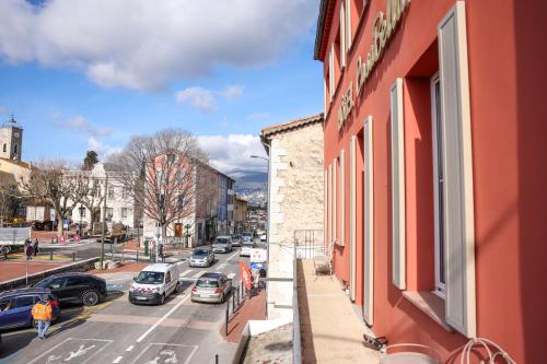 a red building with a window on a city street at Hôtel CASABELLA Cannes Mouans Sartoux in Mouans-Sartoux
