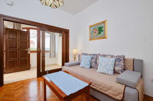 a living room with a couch and a table at Apartments Katja in Mali Lošinj