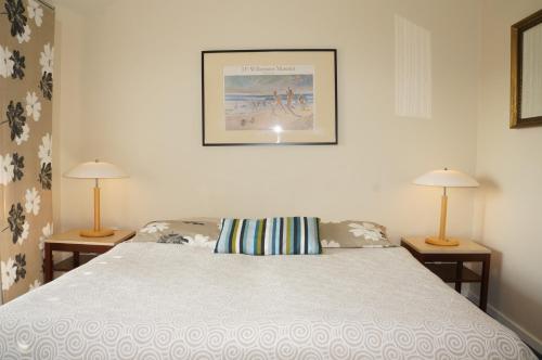 a bedroom with a bed with two lamps on both sides at Tiendegaarden Møns Klint in Borre