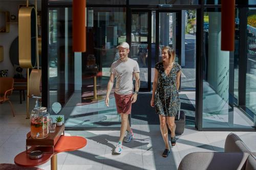 a man and a woman walking in front of a building at Adagio access Brussels Delta in Brussels