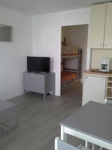 un salon avec une télévision à écran plat sur une armoire dans l'établissement Studio grau du roi, au Grau-du-Roi