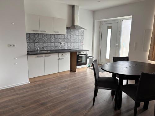 a kitchen and dining room with a table and chairs at Apartments & Zimmer Jembke in Jembke