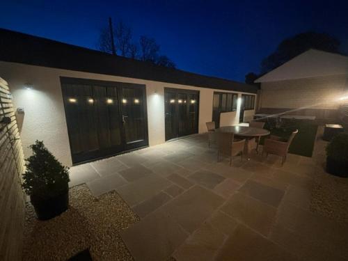 a patio with a table and chairs in front of a building at Laurel Lodge - Stylish Two Bed & Free Parking in Box