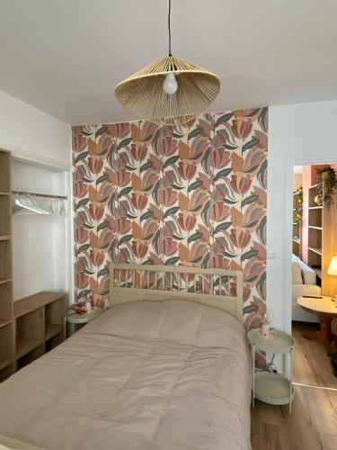 - une chambre avec un grand lit et du papier peint floral dans l'établissement Douce Escale en Plein Centre - Avec Parking privé, à Boulogne-sur-Mer