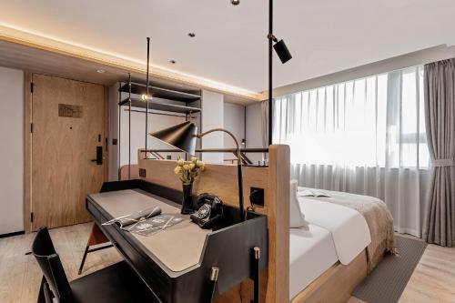 a hotel room with a bed and a desk with a desk at Cheens Hotel in Chengdu