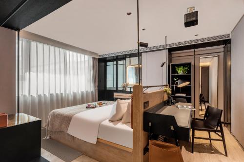 a bedroom with a bed and a desk and a table at Cheens Hotel in Chengdu