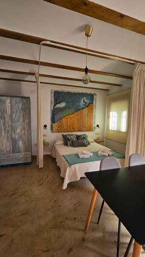 a bedroom with a bed and a painting on the wall at La Tina, la pariera in Santiago de la Espada