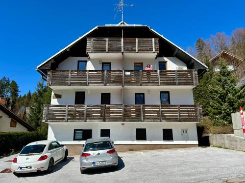 two cars parked in a parking lot in front of a building at Apartment Crystal Rose in Kranjska Gora