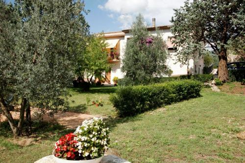 a house with a garden with flowers in a yard at Agriturismo La Pila in Ferentillo