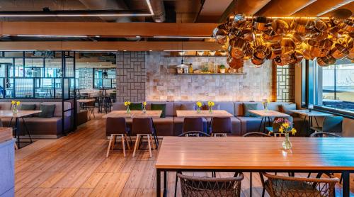 a restaurant with wooden tables and chairs in a room at Original Sokos Hotel Puijonsarvi in Kuopio