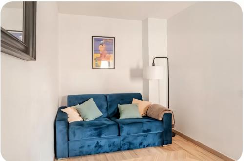 un canapé bleu dans un salon avec un miroir dans l'établissement L'appartement de la Roquette centre historique Arles, à Arles