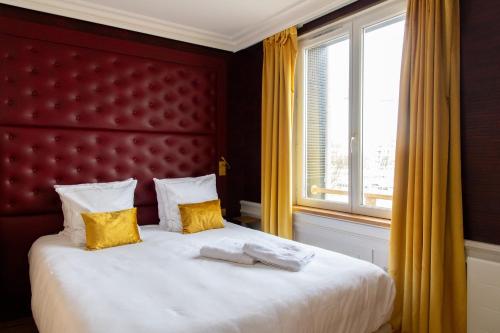 a bedroom with a large bed with yellow curtains and a window at Les chambres du Waterzooi in Dunkerque