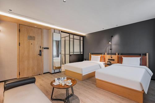 a hotel room with two beds and a table at Cheens Hotel in Chengdu