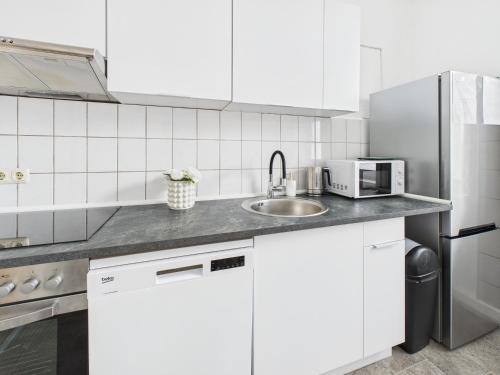 a white kitchen with a sink and a microwave at Loft & Living am Geiseltalsee in Braunsbedra