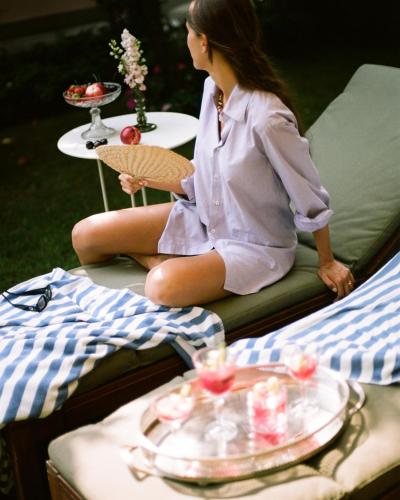 a woman sitting on a couch with a table with food at Relais La Foleia - Luxury Villa with private lake in Veruno
