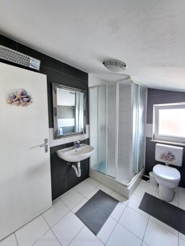 a bathroom with a toilet and a sink at Apartment Perla in Dinjiška