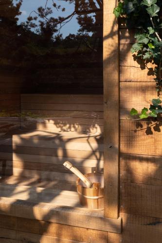 a wooden fence with a bucket on a patio at Relais La Foleia - Luxury Villa with private lake in Veruno