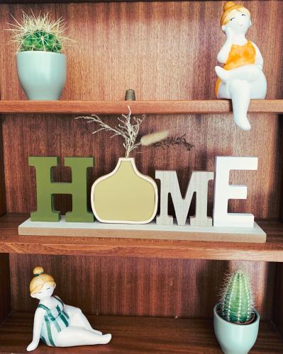 a wooden shelf with a me sign and plants at Amélia's House in Seixal