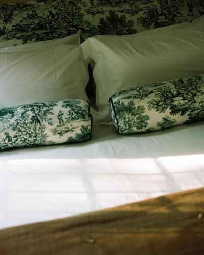 a bed with two pillows on top of it at Relais La Foleia - Luxury Villa with private lake in Veruno