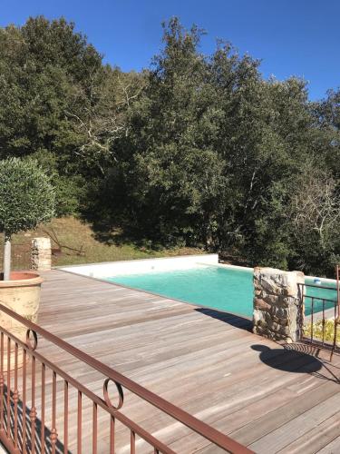 une terrasse en bois à côté d'une piscine dans l'établissement Mas La Solarie au coeur des Cévennes avec accès privé à la rivière, à Thoiras