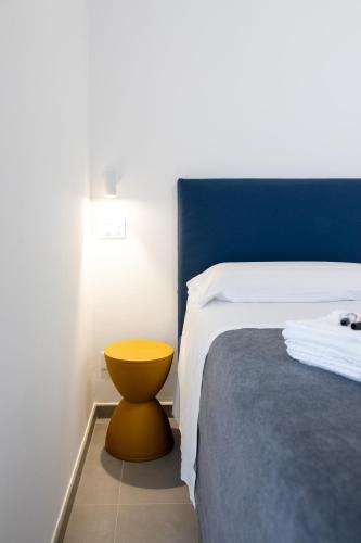 a bedroom with a bed with a yellow stool next to it at Amarena Vacanze in Porto Recanati