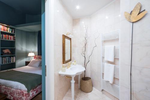 a bedroom with a bed and a sink and a mirror at Relais La Foleia - Luxury Villa with private lake in Veruno