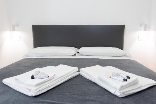 a bed with two white towels on top of it at Amarena Vacanze in Porto Recanati