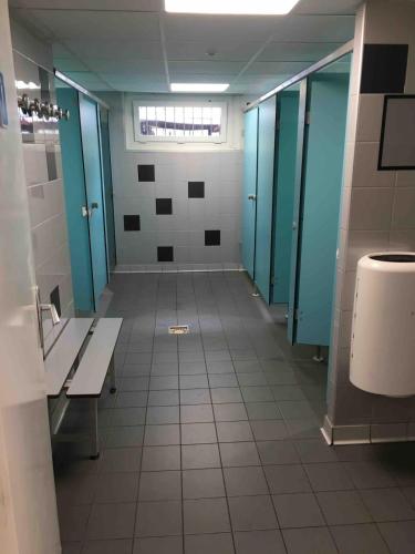 un couloir d'une salle de bains avec bancs et stalles dans l'établissement Bateau au coeur d'Hendaye, à Hendaye